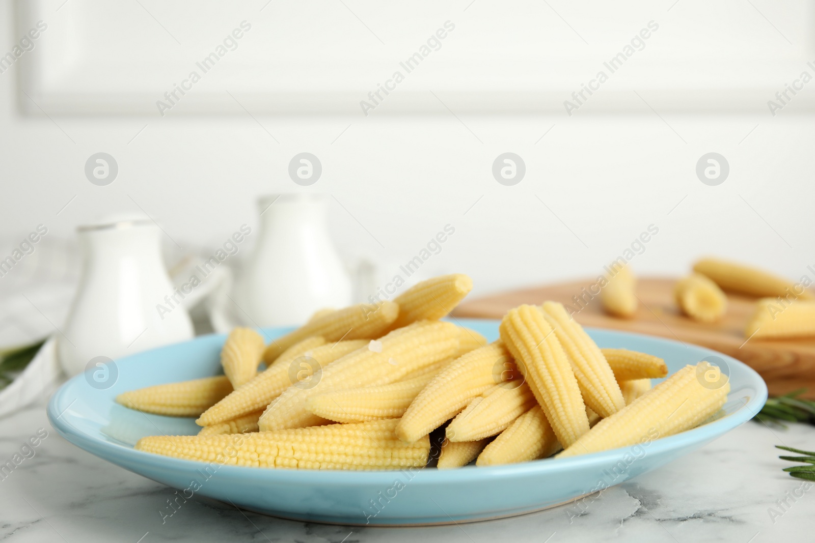 Photo of Fresh baby corn cobs on white marble table