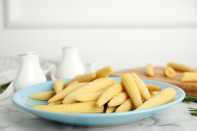 Fresh baby corn cobs on white marble table