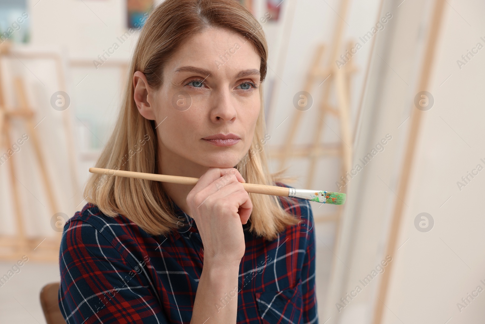 Photo of Woman painting on canvas in studio. Creative hobby