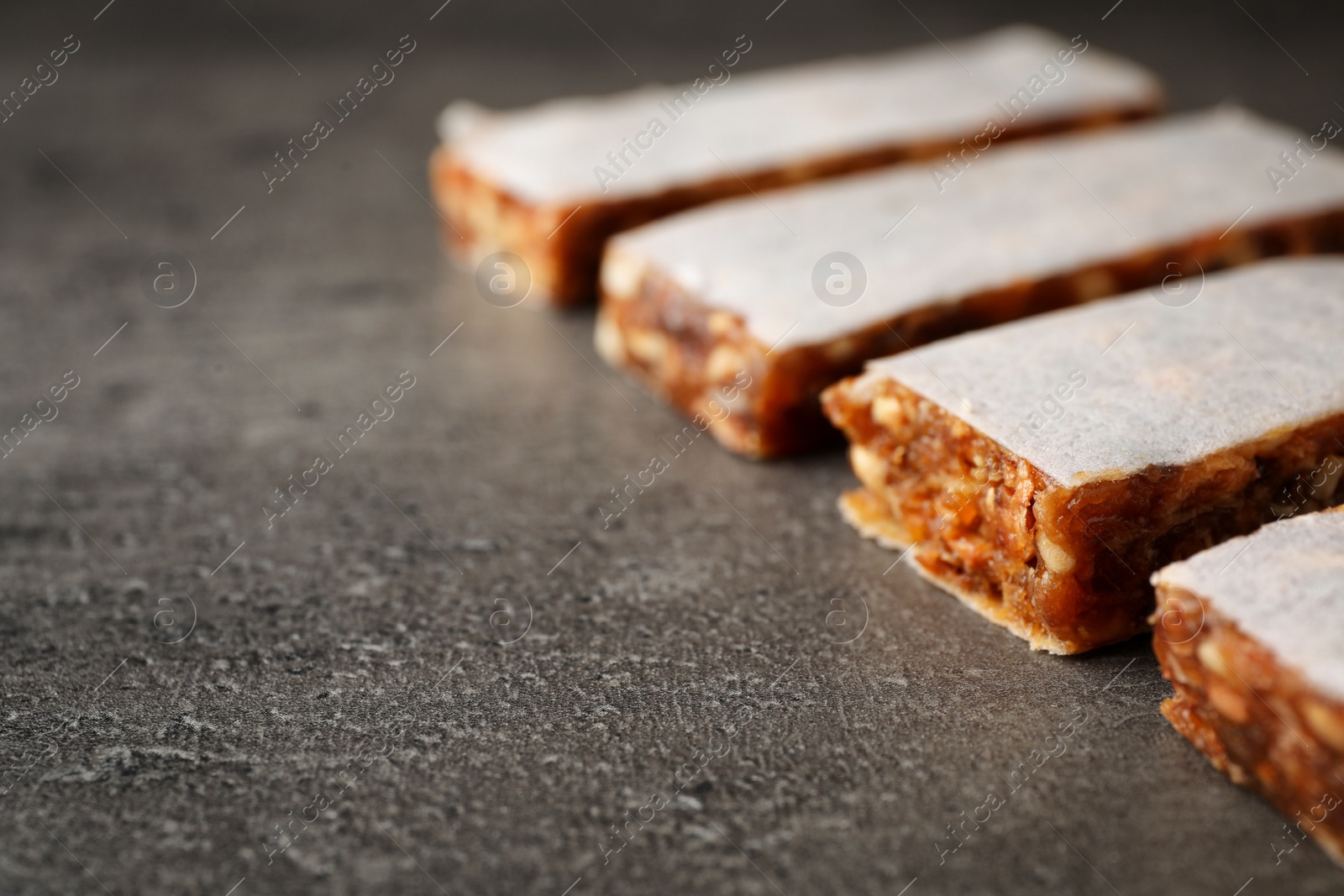 Photo of Tasty protein bars on grey table. Space for text