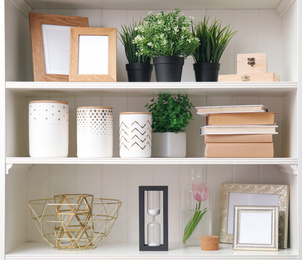 White shelving unit with plants and different decorative stuff