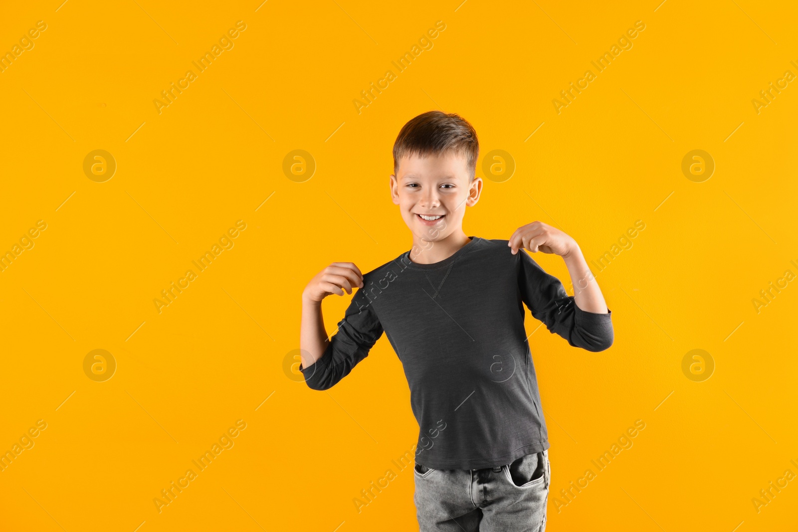 Photo of Little boy in long sleeve t-shirt on color background. Mock-up for design