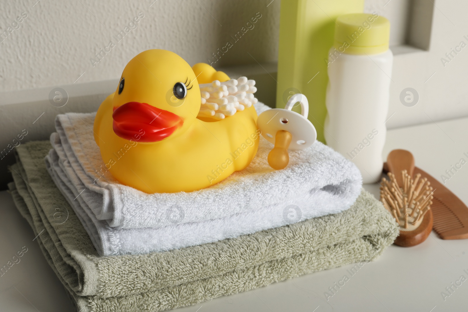 Photo of Bathroom towels, toy and baby accessories on white table