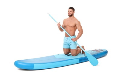 Photo of Handsome man with paddle on blue SUP board against white background