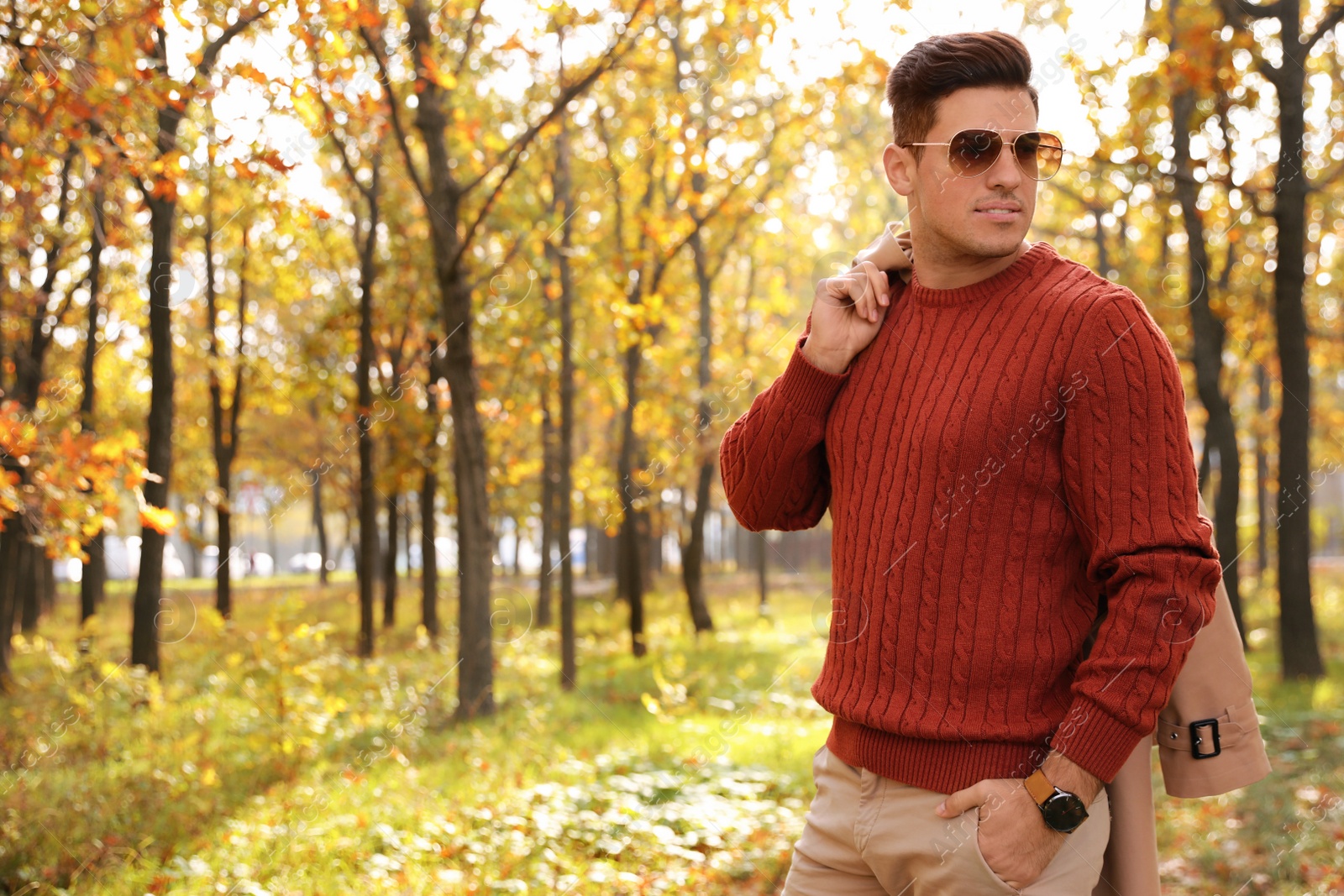 Photo of Handsome man walking in park on autumn day
