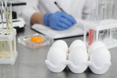 Photo of Scientist proceeding quality control in laboratory, focus on fresh eggs