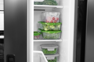 Glass and plastic containers with different fresh products in fridge. Food storage