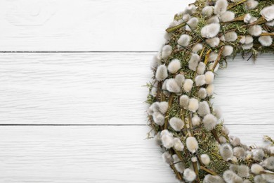 Photo of Wreath made of beautiful willow flowers on white wooden table, top view. Space for text
