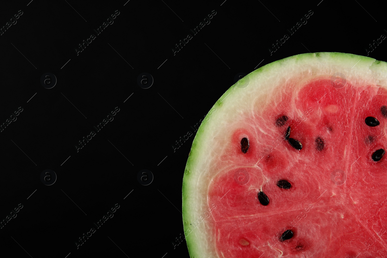 Photo of Slice of watermelon on black background, closeup