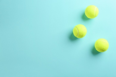 Photo of Tennis balls on light blue background, flat lay. Space for text