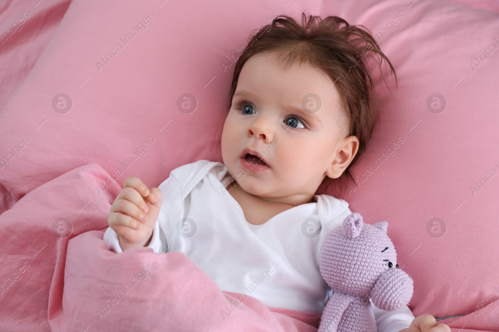 Photo of Cute little baby with toy on bed