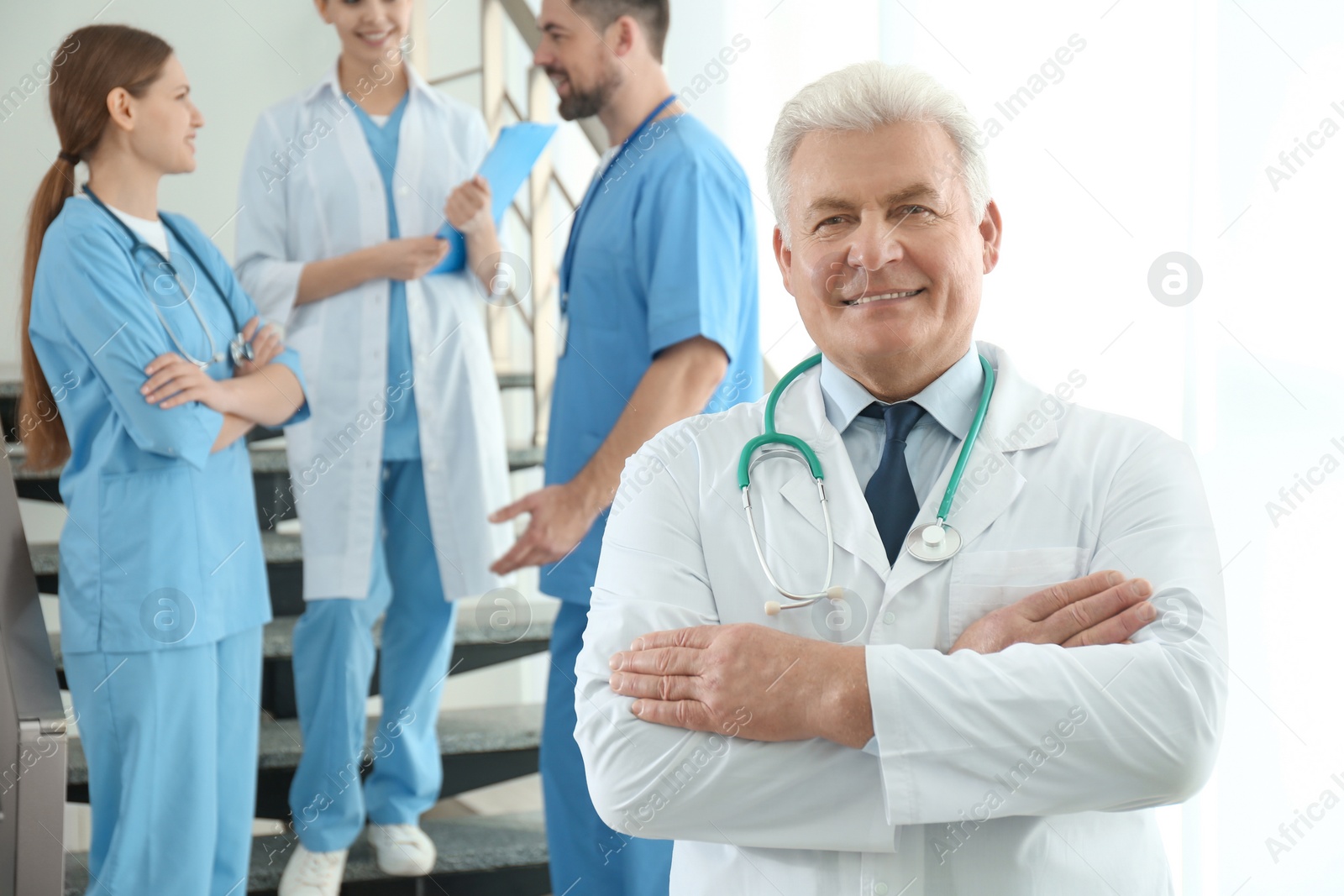 Photo of Senior doctor and colleagues in hospital. Medical service