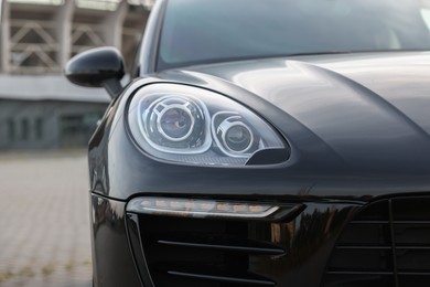 Photo of Modern black car parked outdoors, closeup view