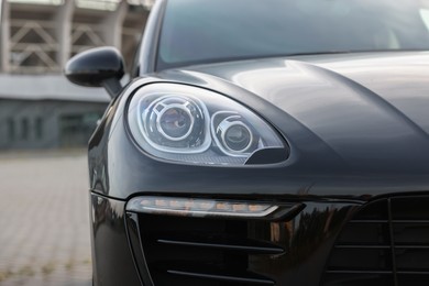 Modern black car parked outdoors, closeup view