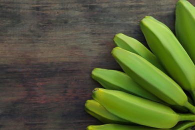 Bunch of delicious bananas on wooden table, top view. Space for text