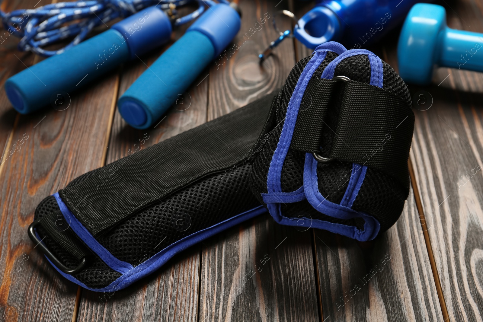 Photo of Blue weighting agents and sport equipment on wooden table