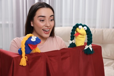 Photo of Excited woman performing puppet show at home