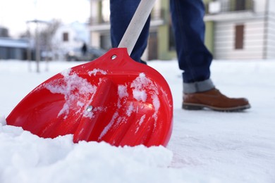 Photo of Man shoveling snow on city street, closeup