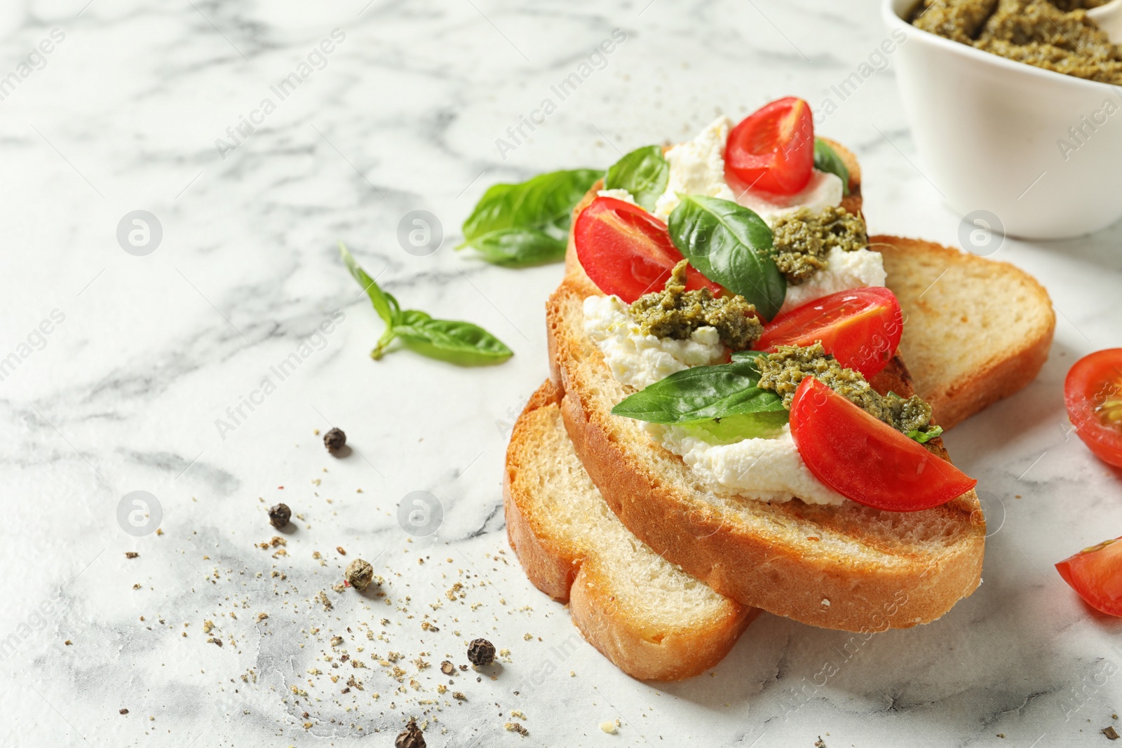 Photo of Toasted bread with tasty cream cheese and tomatoes on marble table. Space for text