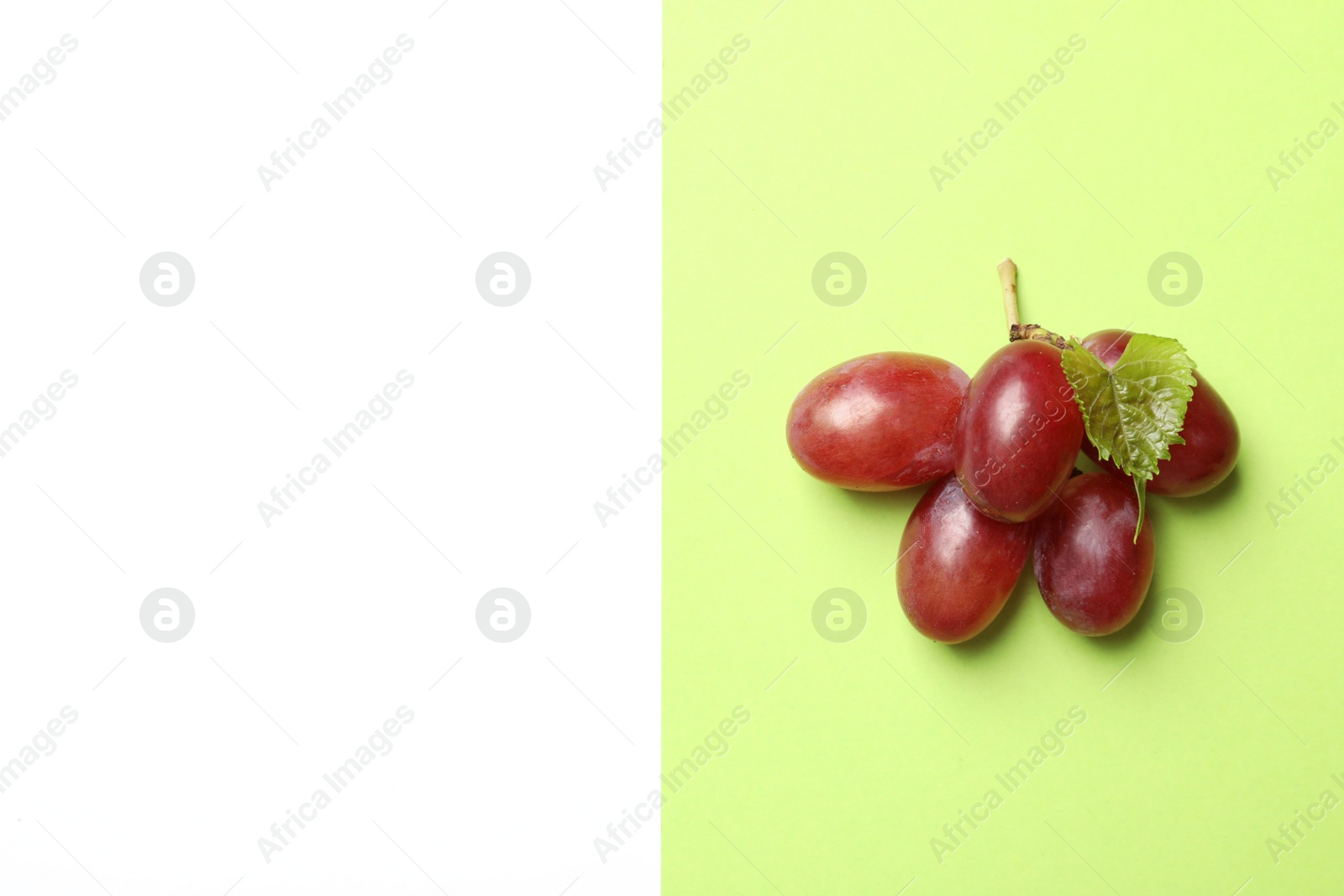 Photo of Fresh ripe juicy grapes on color background, top view. Space for text