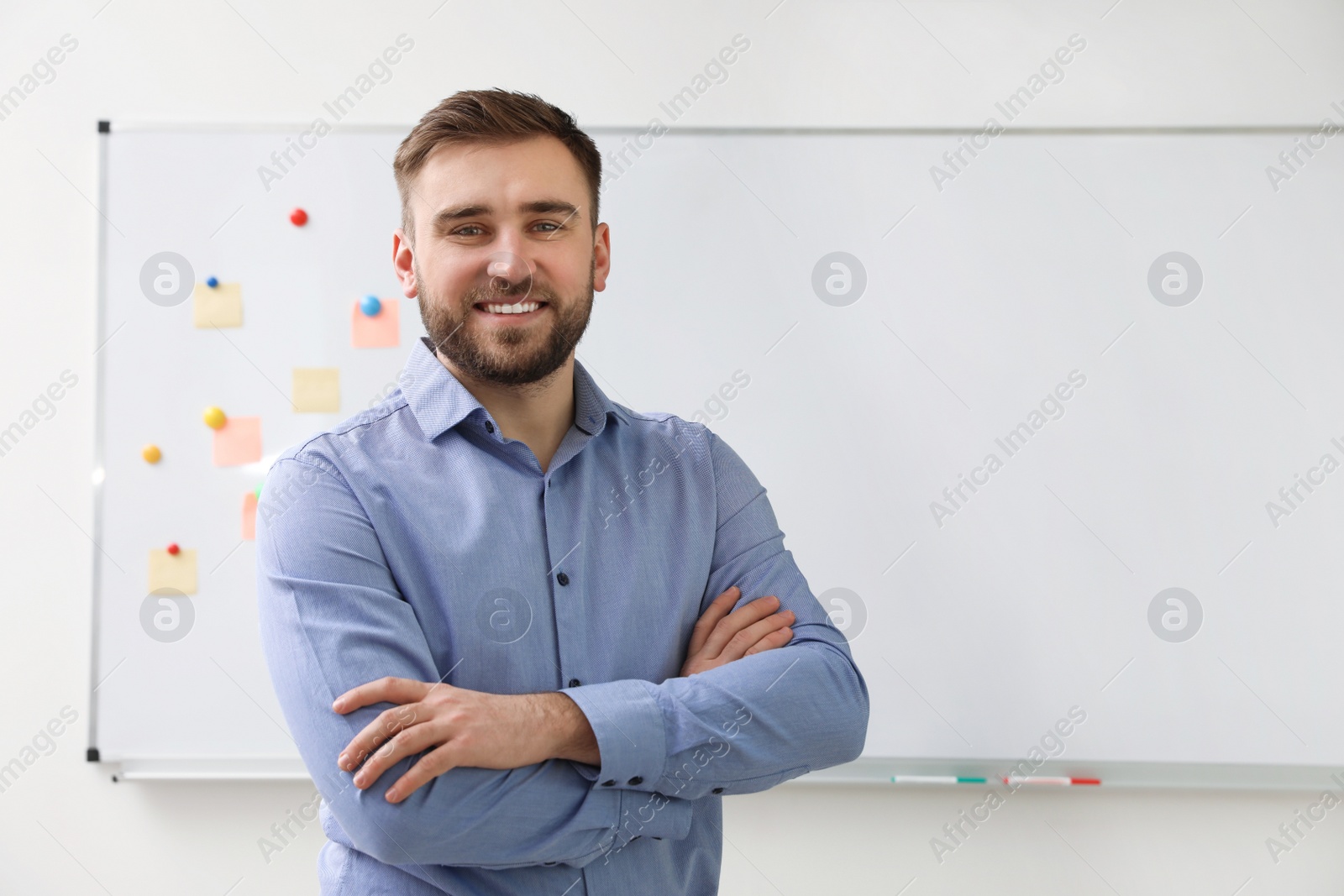 Photo of Portrait of young teacher near whiteboard in classroom