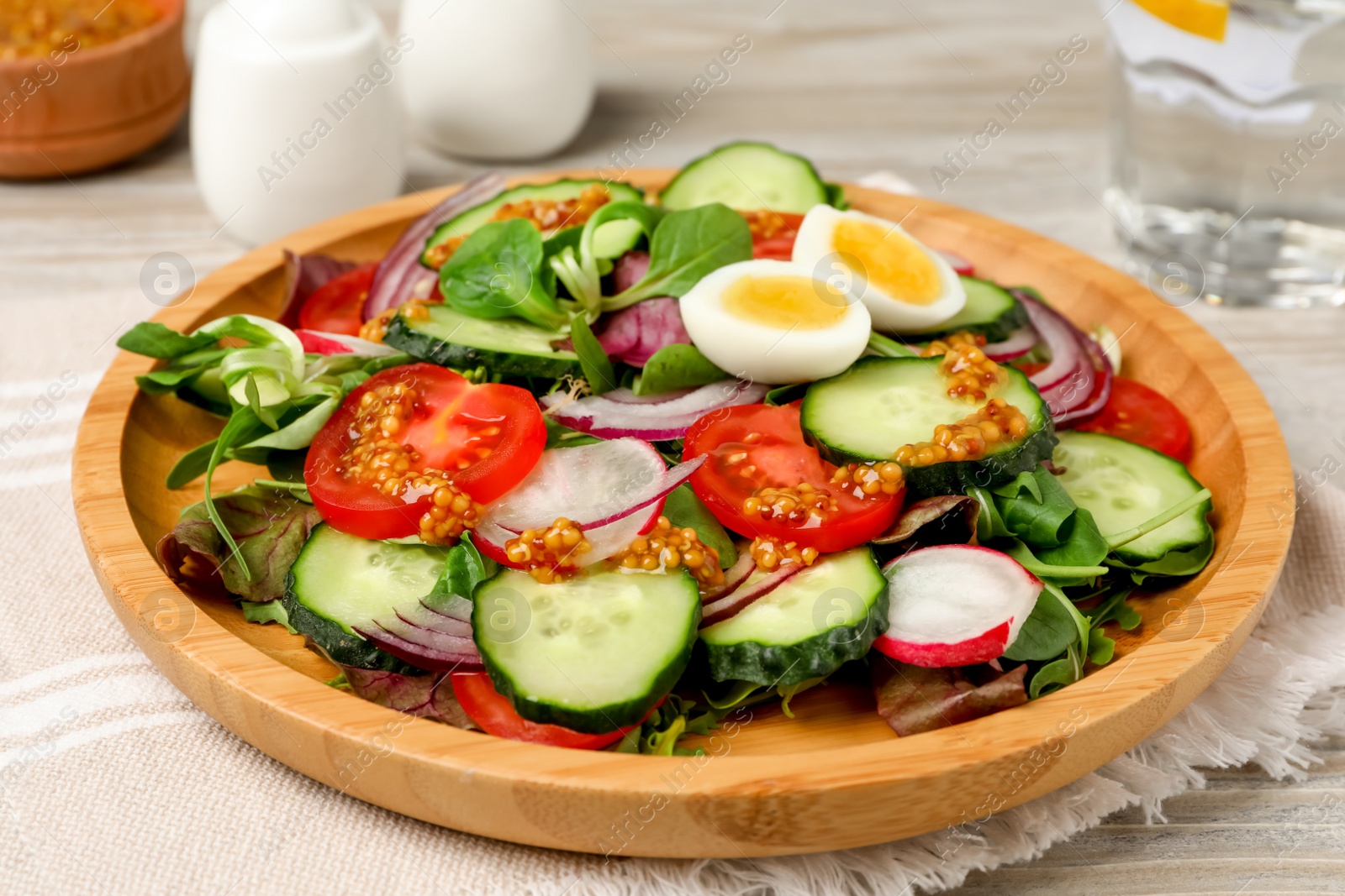 Photo of Tasty salad with vegetables and quail eggs on wooden table, closeup