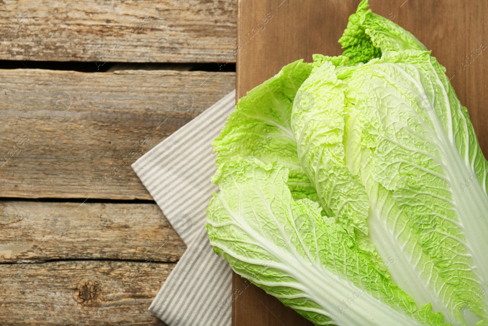 Photo of Fresh ripe Chinese cabbage on wooden table, top view. Space for text