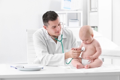 Photo of Children's doctor examining baby with stethoscope in hospital