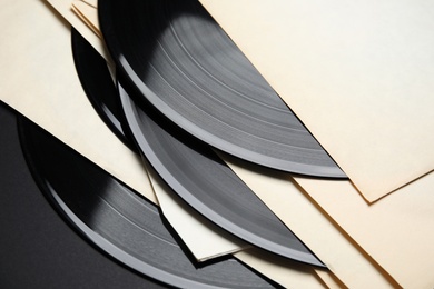 Photo of Vintage vinyl records in paper sleeves on black background, closeup