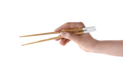 Woman holding pair of wooden chopsticks on white background, closeup