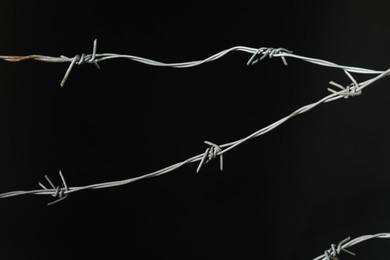 Photo of Shiny metal barbed wire on black background