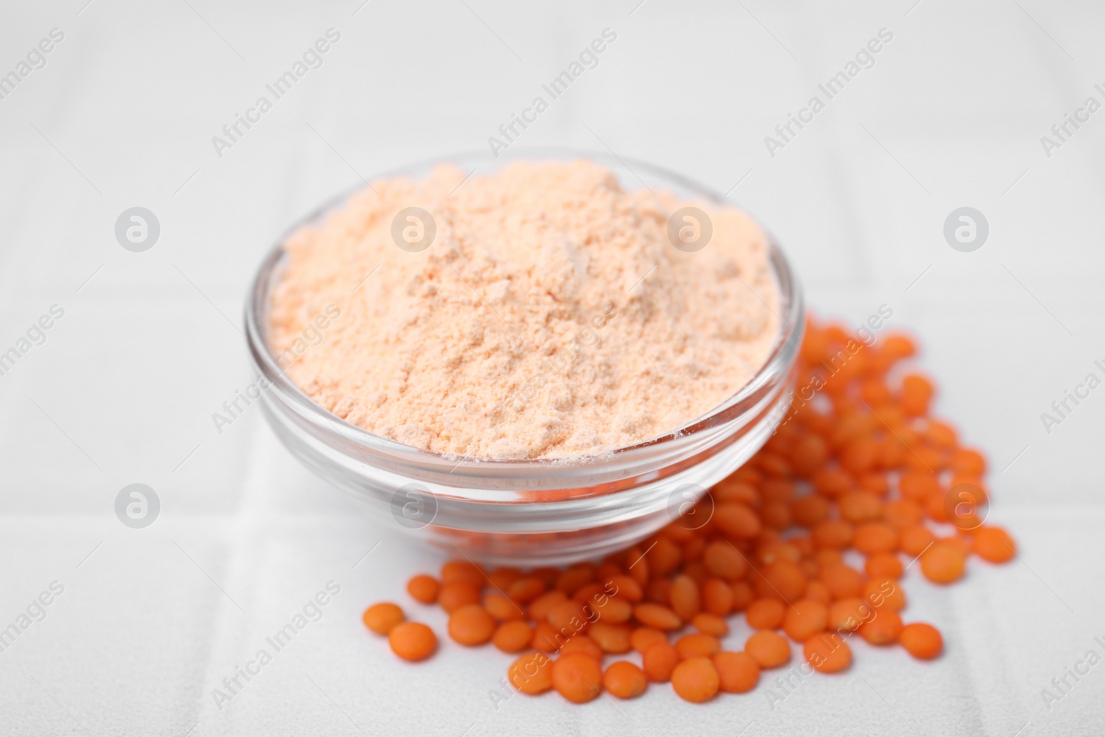 Photo of Bowl of lentil flour and seeds on white tiled table