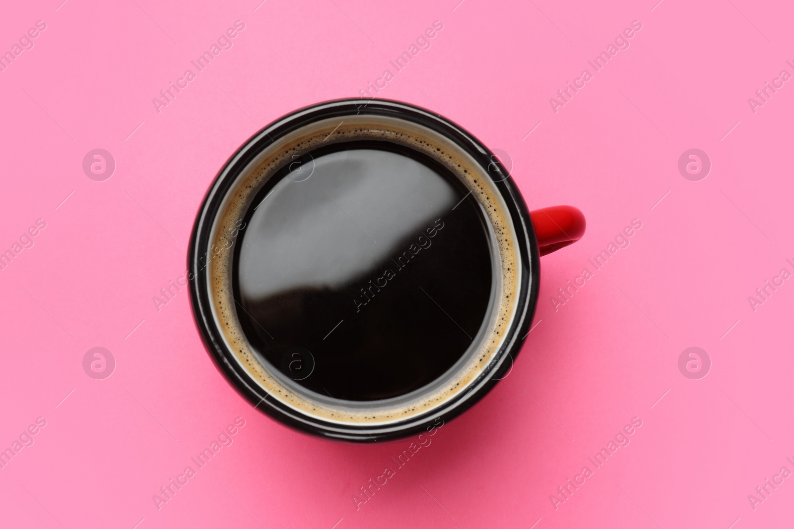 Photo of Fresh coffee in cup on pink background, top view