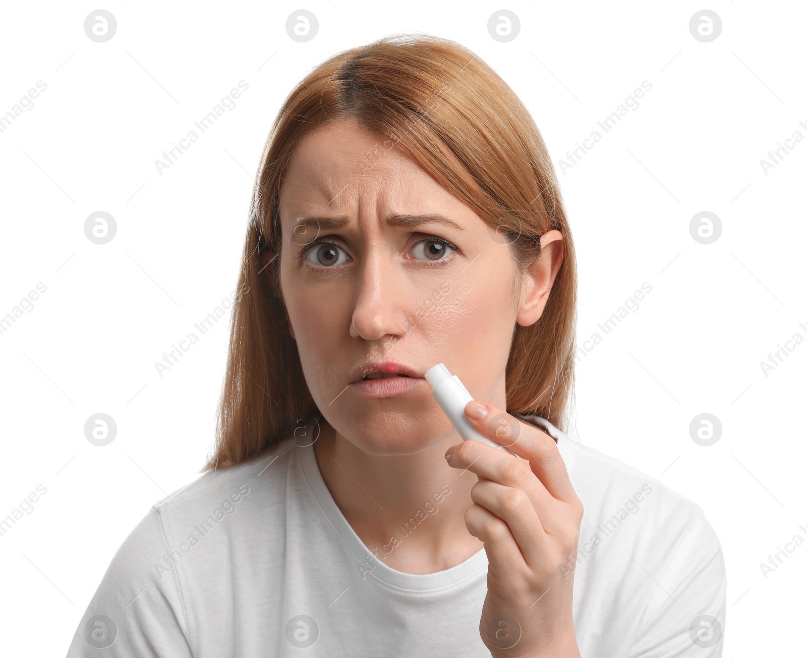 Photo of Upset woman with herpes applying lip balm against white background