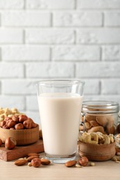 Photo of Vegan milk and different nuts on wooden table