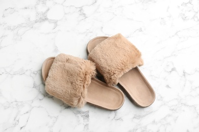 Photo of Pair of soft slippers on white marble background, flat lay