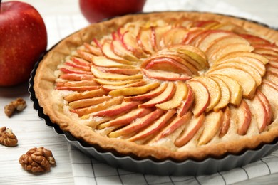 Delicious homemade apple tart on white wooden table, closeup