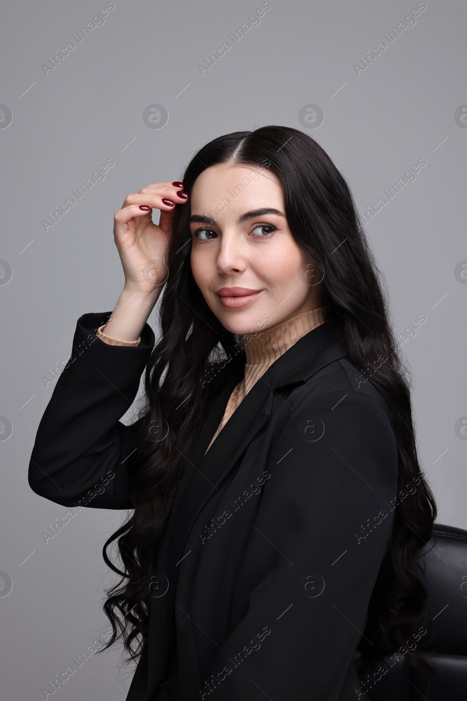 Photo of Beautiful woman in black jacket on gray background