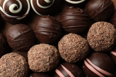 Photo of Many different delicious chocolate truffles, top view