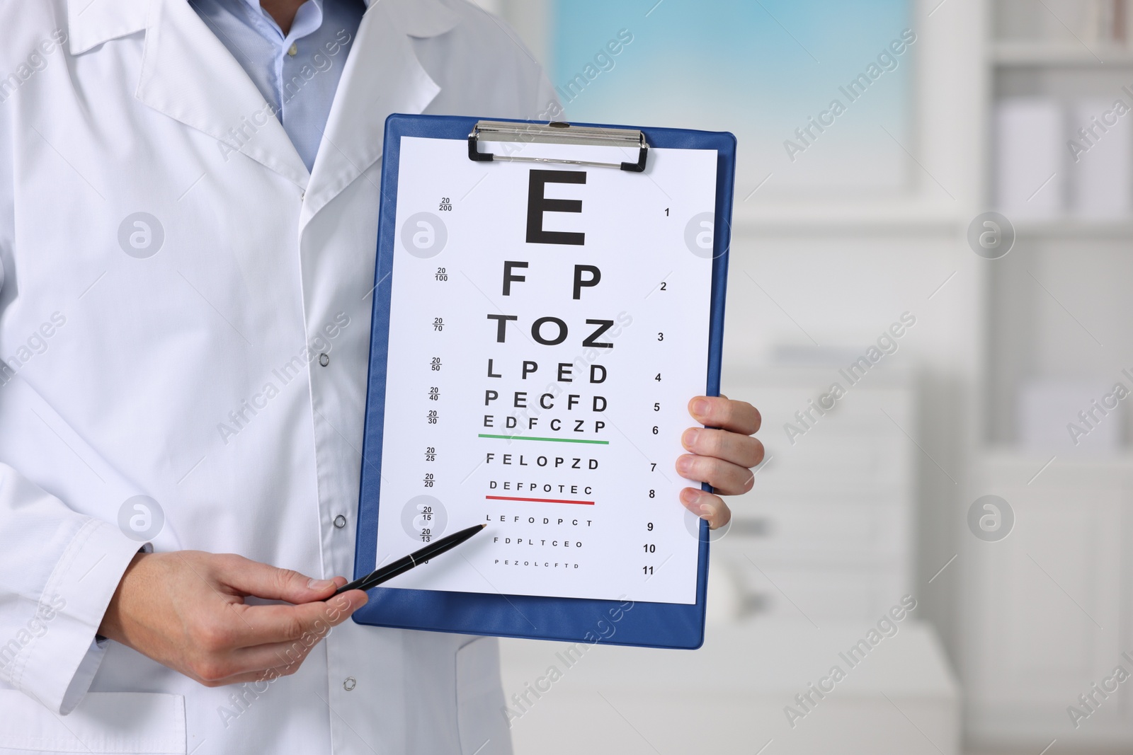 Photo of Ophthalmologist pointing at vision test chart in clinic, closeup