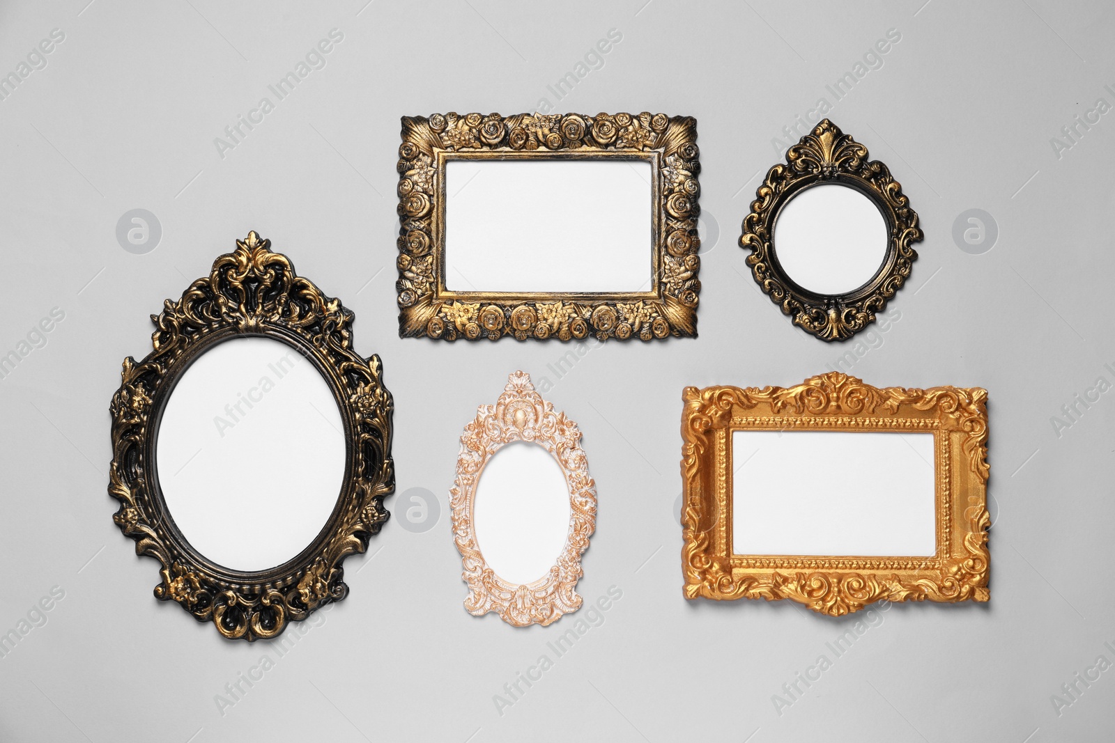 Photo of Empty vintage frames hanging on light gray wall