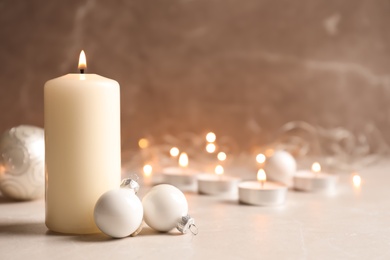 Burning wax candle and Christmas decorations on table