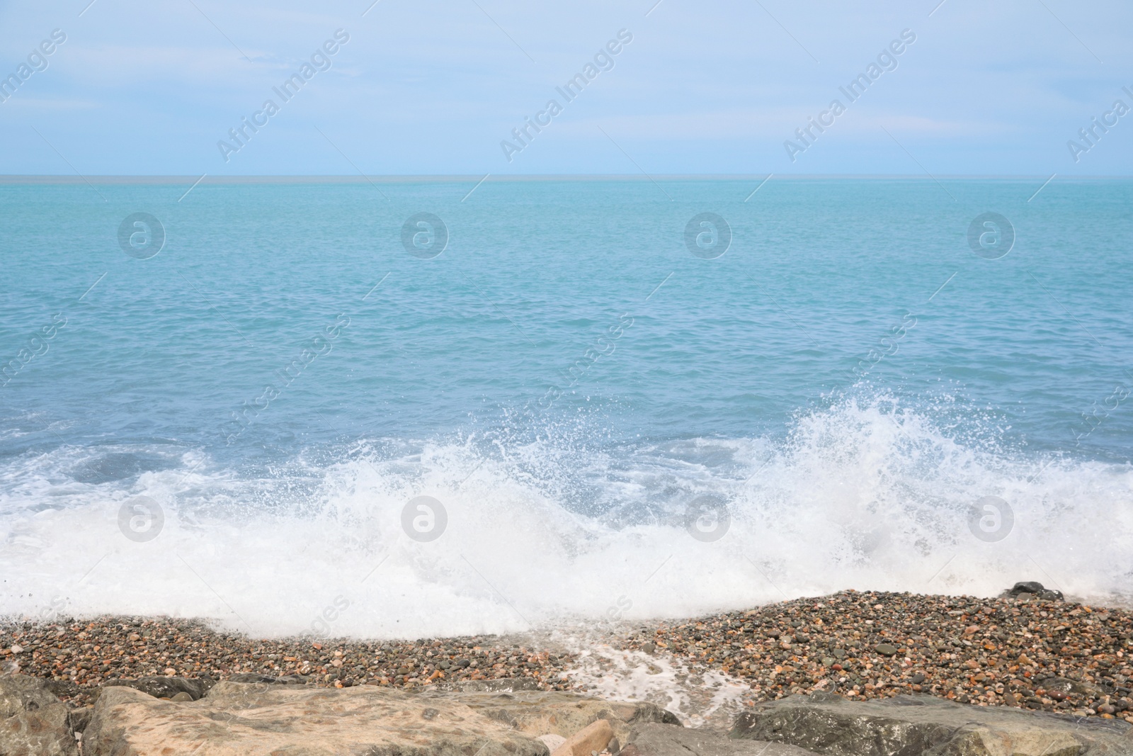 Photo of Picturesque view of foamy waves hitting rocky shore