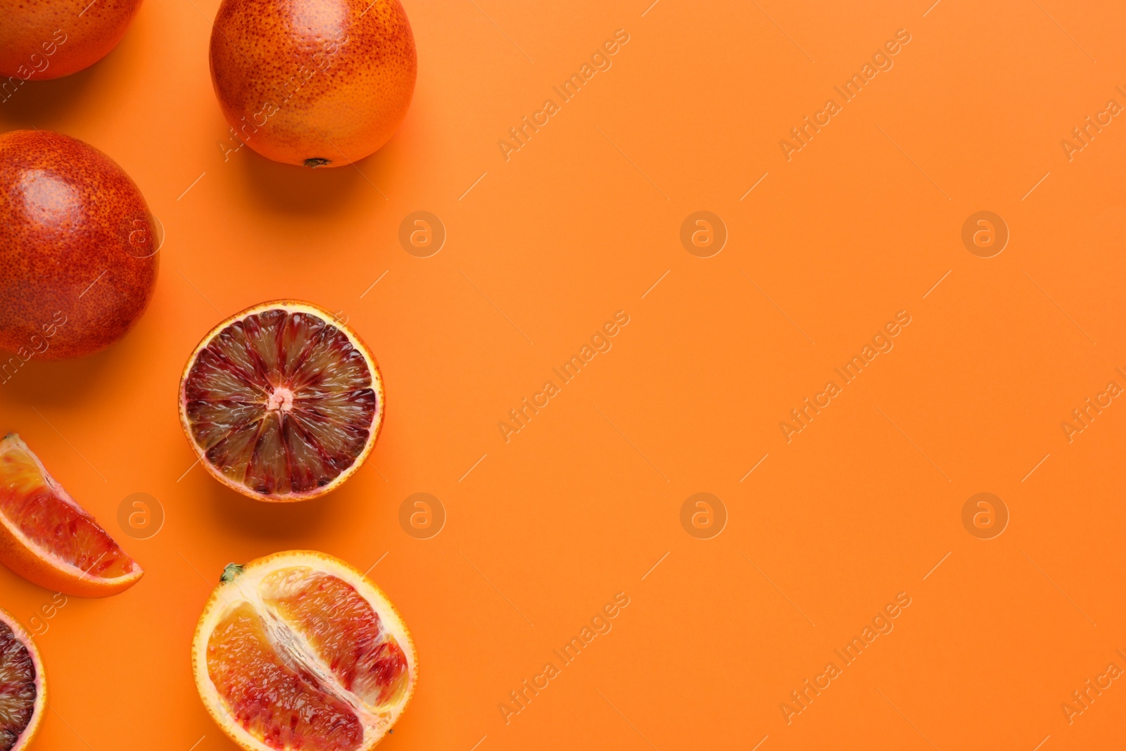 Photo of Many ripe sicilian oranges on orange background, flat lay. Space for text