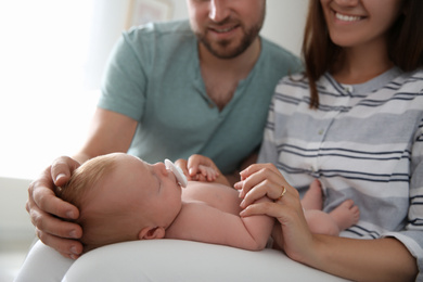 Happy couple with their newborn baby at home, closeup