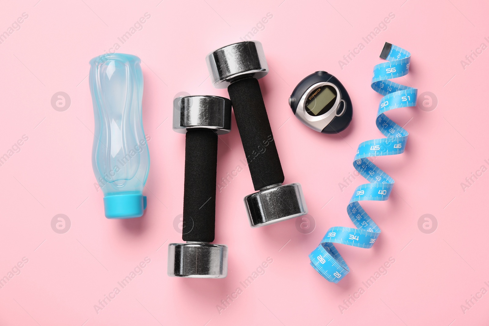 Photo of Flat lay composition with dumbbells on pink background