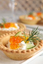 Delicious canapes with red caviar on table, closeup