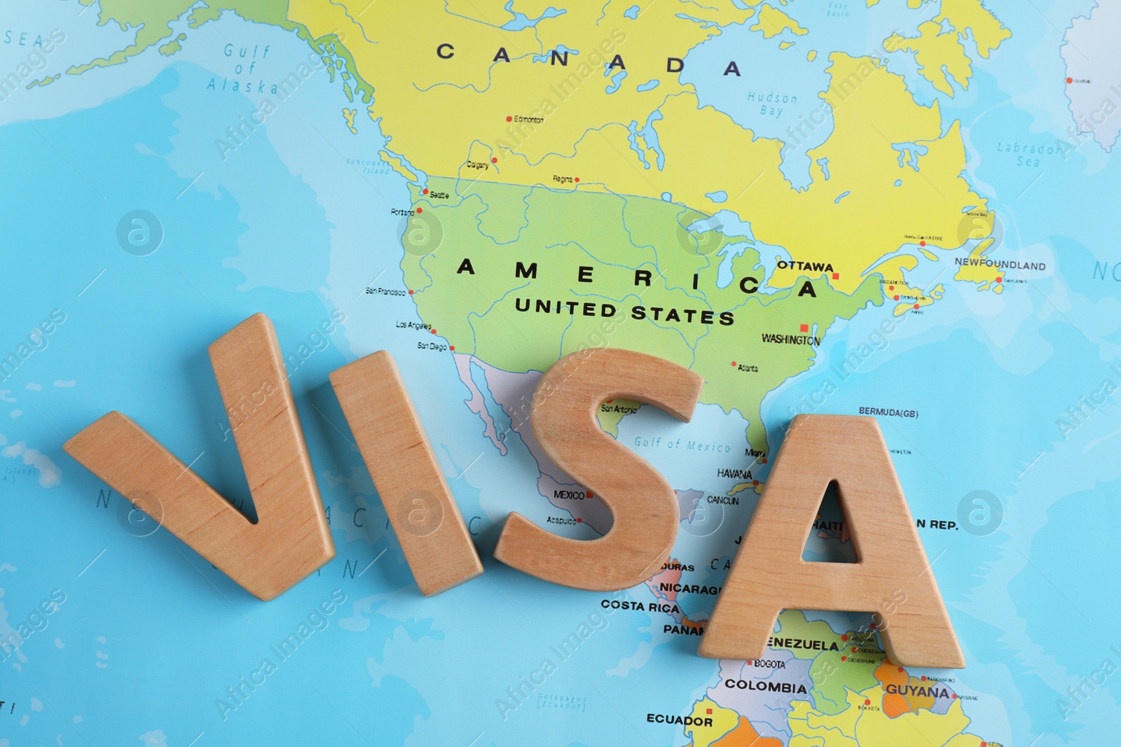Photo of Word Visa made of wooden letters near USA on world map, top view