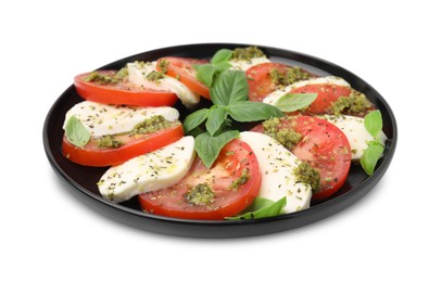 Photo of Plate of delicious Caprese salad with pesto sauce isolated on white