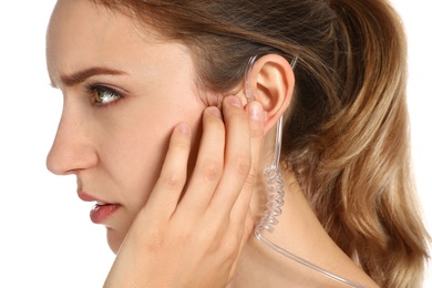 Female security guard using radio earpiece on white background, closeup